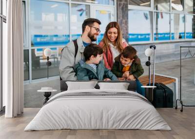 Happy ypung family with luggage in railroad station go together on vacation. Wall mural