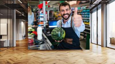 Portrait of handsome smiling male cashier working at a grocery store. Wall mural