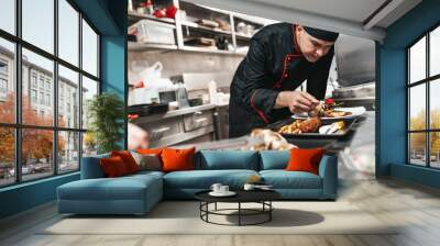 Professional chef arranging food plate with meat and vegetables. Wall mural