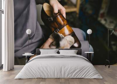 Shoemaker in workshop polishing new handmade beautiful leather shoes. Wall mural