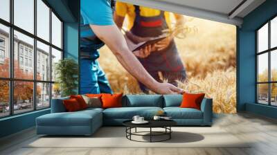 Two agronomists inspecting wheat field and using tablet computer. Wall mural