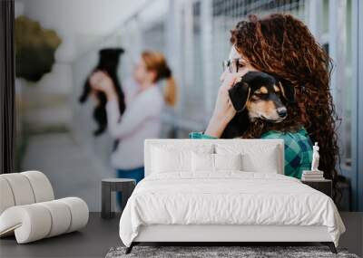 Two young adult women adopting beautiful dogs at animal shelter. Wall mural