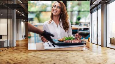 Young beautiful and happy woman enjoying in delicious meal in luxurious restaurant. Wall mural