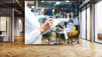 Young happy female worker in factory checking water bottles or gallons before shipment. Inspection quality control.  Wall mural