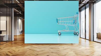 Empty shopping cart on a blue background Wall mural