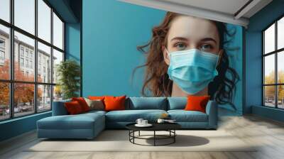 Person wearing surgical mask on blue background Wall mural