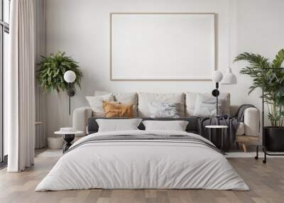 white sofa with cushions and a gray throw blanket in a living room with an empty picture frame and two plants in pots
 Wall mural