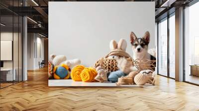 A carnivore fawn puppy with whiskers is sitting in a basket surrounded by toy knitted toys. The scene looks like a piece of art with stuffed toys as fashion accessories Wall mural