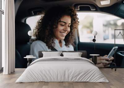 Woman smiling joyfully while looking at his phone in his car. Wall mural