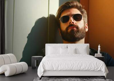 Stylish Bearded Man in Sunglasses Relaxing Against Sunlit Wall Wall mural