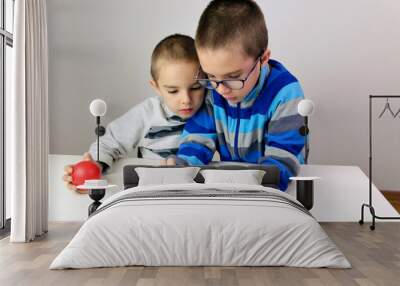 Two little boys playing a game on the smartphone Wall mural