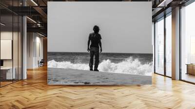 Man alone at the beach looking at the waves Wall mural