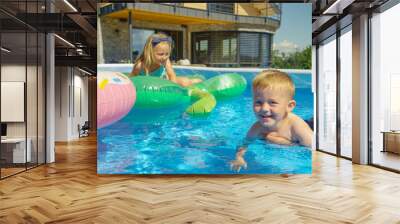 CLOSE UP: Smiling little boy floating in backyard swimming pool learning to swim Wall mural