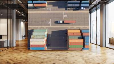 TOP DOWN: White truck transports a red freight container across the busy port. Wall mural