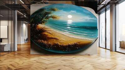 A hand holds a glass plate with a painted seascape of a beach, ocean and sky. Wall mural