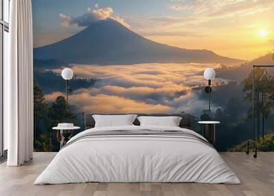 A majestic mountain peak rises above a sea of clouds at sunrise, casting a golden glow on the landscape. Wall mural