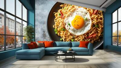 A plate of instant noodles topped with a fried egg, green onions, and chili peppers. Wall mural