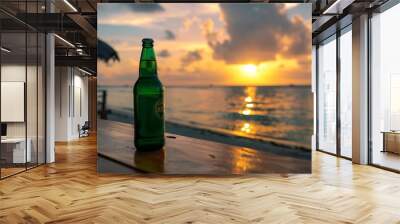 A single bottle of beer sits on a table overlooking a tropical beach at sunset. Wall mural