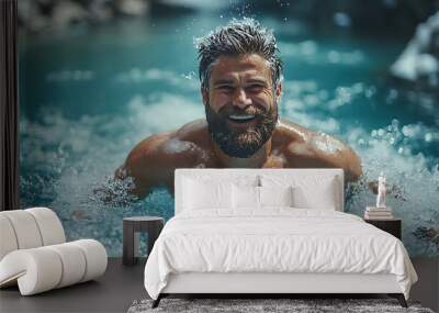 A smiling man with a beard swims in a mountain stream. Wall mural