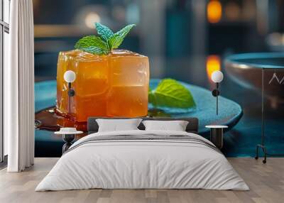 A square piece of orange jelly on a plate with mint leaves and caramel sauce. Wall mural