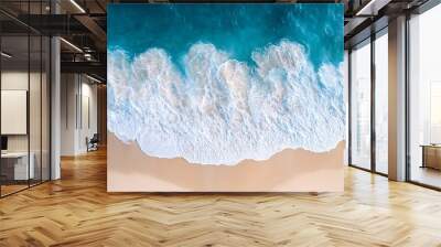 Aerial view of white waves crashing on a sandy beach. Wall mural