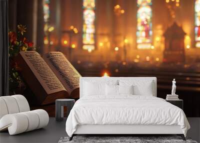 An open bible with a lit candle rests on a wooden table in the front of an ornate church. Wall mural