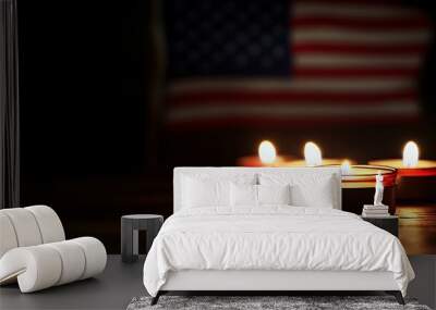 Four lit candles on a wooden surface with an American flag in the background. Wall mural