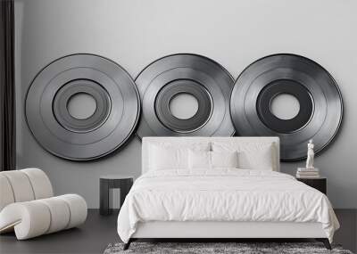 Three metallic disks arranged in a row on a white background. Wall mural