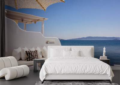 Typical Greek luxury decoration facing the sea to relax with whitewashed walls and comfortable cushions and perfect view on the blue Aeagean Sea in Milos Island in Greece Wall mural