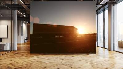 Modern wagon truck transports cargo against the backdrop of a sunset. The concept of truck drivers in the field of freight and logistics, copy space, trailer Wall mural