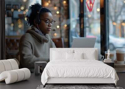 Nomad lifestyle concept. Black female working remotely from a coffee shop with her laptop Wall mural