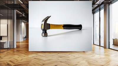 A claw hammer with a yellow and black handle on a white background. Wall mural