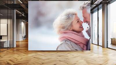 Senior couple in love holding each other close. Snow falling around them, concept of wintertime and long love. Banner with copy space and shallow field of view. Wall mural