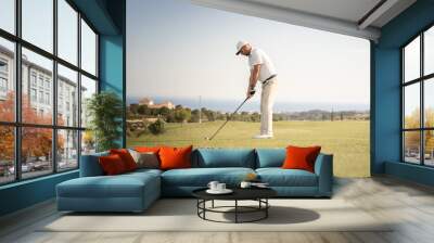 Golfer getting ready to hit the ball. Wall mural