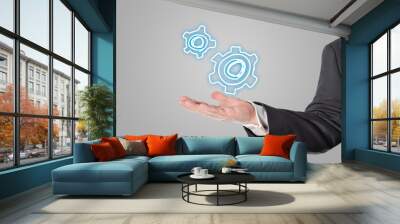 Businessman, salesman, gear symbol in the hand Wall mural