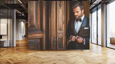 A man in a black suit and bow tie is standing in front of a wooden door Wall mural