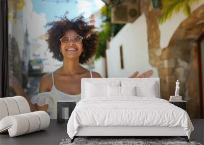 A woman with curly hair is smiling and wearing a white dress Wall mural