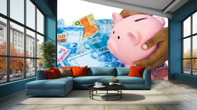 Hands holding piggy bank surrounded by real notes Wall mural