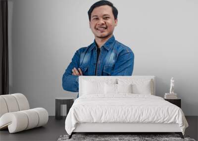 Young Asian Man folded arms looking at camera with happy face expression on isolated background Wall mural