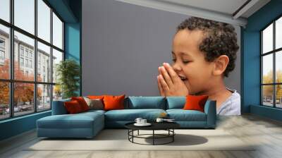 boy praying to God with hands held together with closed eyes on white background stock photo Wall mural