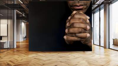 man praying to god with hands together Caribbean man praying on black background with people stock photos stock photo Wall mural