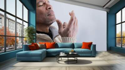 man praying to god with hands together Caribbean man praying with white background stock photo Wall mural