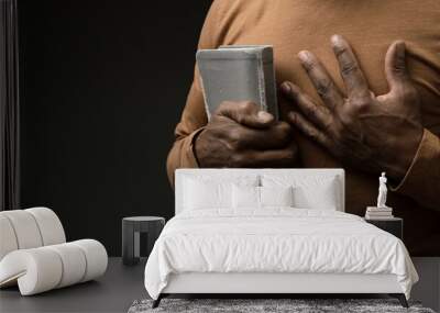 man praying to God with the bible on grey black background with people stock image stock photo Wall mural