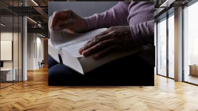 man praying with bible with black background with people stock photo Wall mural