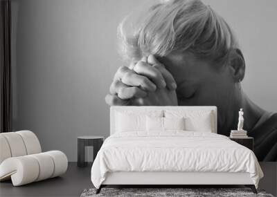 woman praying to god with hands together on grey black background with people stock photo stock image	 Wall mural