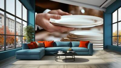 The butler's hand is holding the white plate, which stands on top of several plates with silverware and table Wall mural