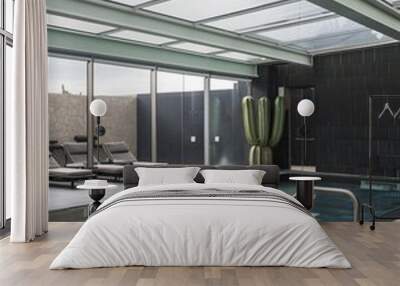 A modern indoor swimming pool with a glass roof, grey tiles, and a cactus plant. Wall mural