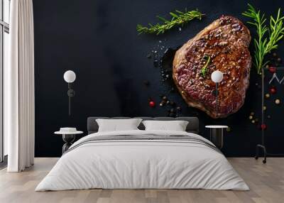 A perfectly cooked steak with herbs and spices on a black background. Wall mural