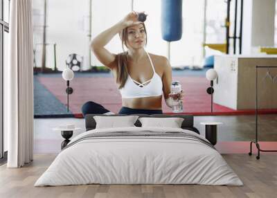 Beautiful girl in a gym. Sports girl in a sportswear. Girl training Wall mural