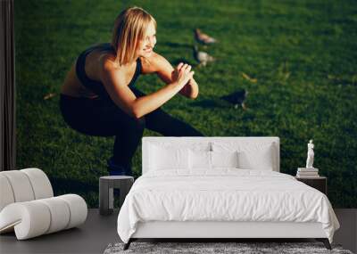 Girl in the park. The beauty is engaged in sports. Morning exercise on the nature. Wall mural